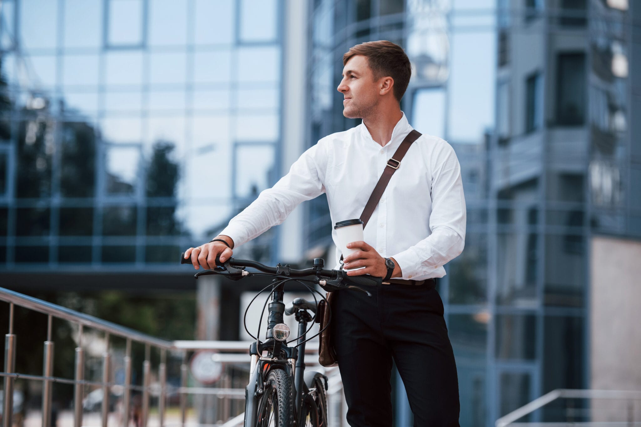 excited businessman in formal clothes with black bicycle is in the city