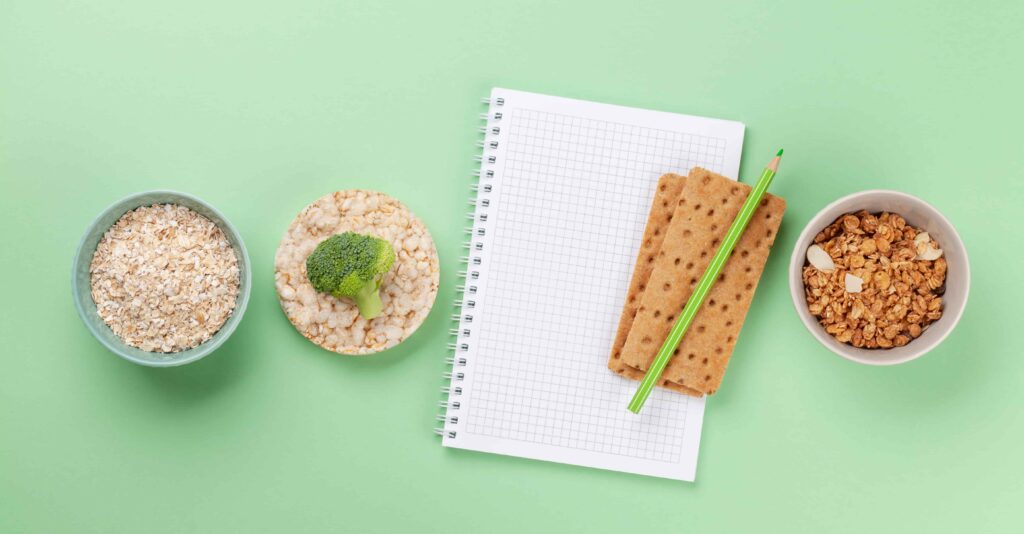 Healthy foods sitting near a notebook and pencil