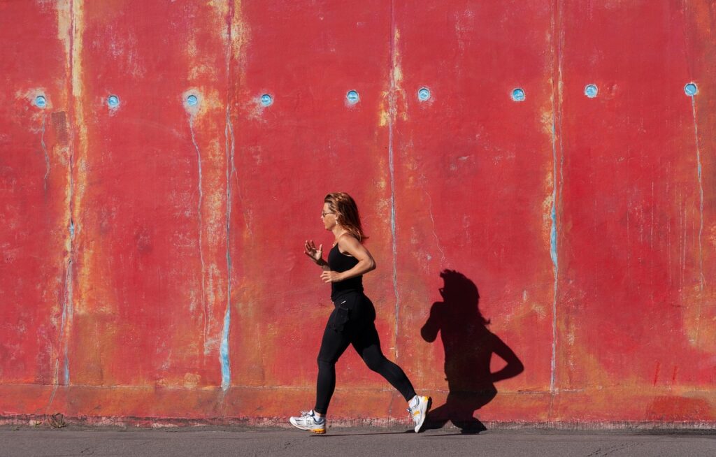 woman_jogging_on_sunny_day_infront_of_red_wall