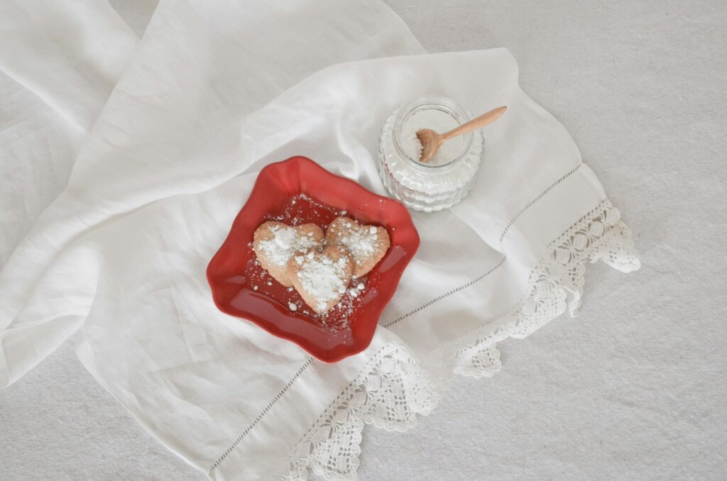 heart_shaped_donuts_with_powdered_sugar_on_red_plate