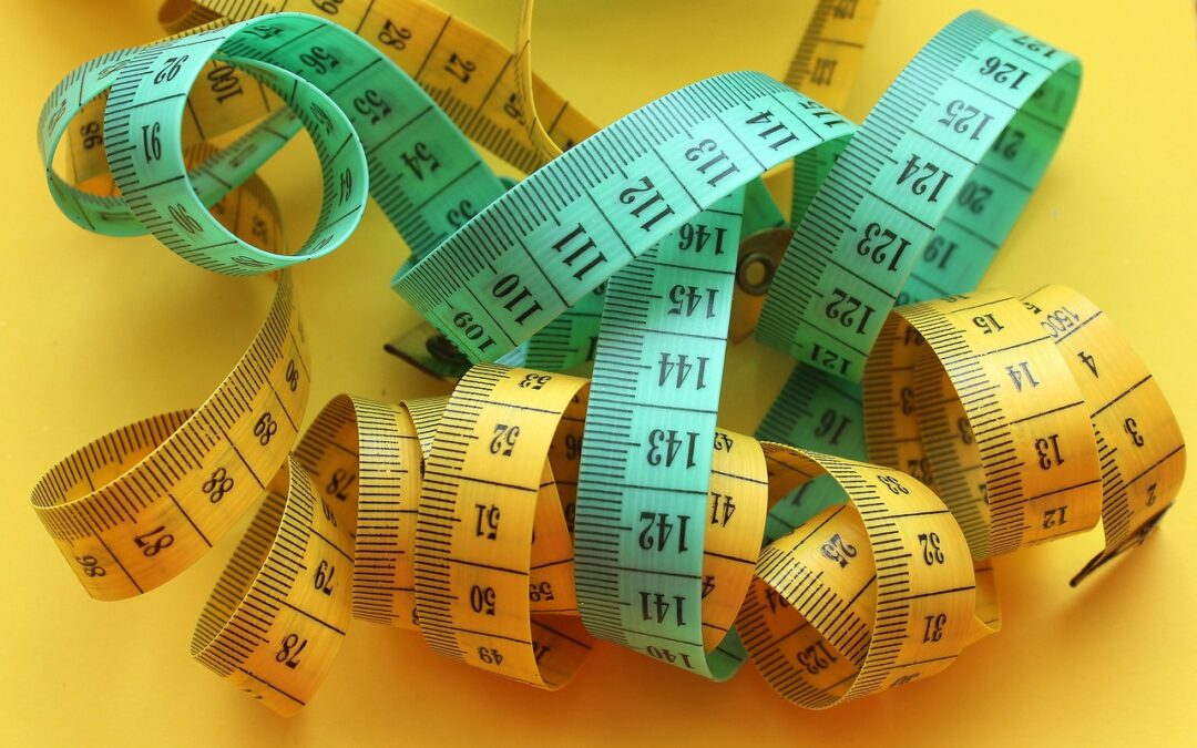 blue and yellow tape measures tangled up on yellow table