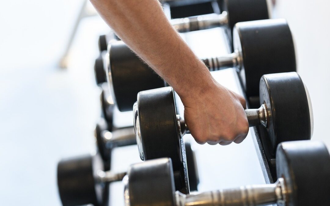 male forearm grabbing weight from weight rack